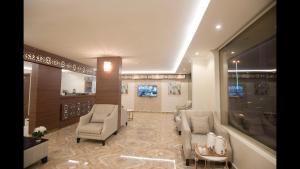 a lobby with two chairs and a waiting room at Janan Al Nakheel Serviced Apartments in Al Muzāḩimīyah