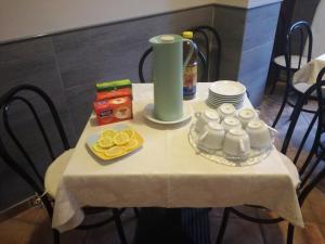 フィウッジにあるB&B Metamorphosiの白いテーブルクロスと食べ物を載せたテーブル