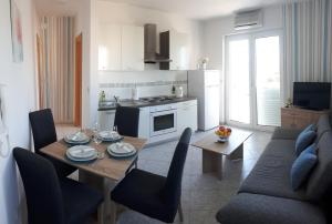 a kitchen and living room with a table and a couch at Apartment Dana in Zadar