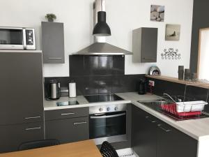 a kitchen with a sink and a stove top oven at Appartement impeccable en centre ville in Givet +7 photos