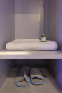 a pair of shoes sitting on a shelf next to a mattress at Passgo Digital Airport Terminal 3 Soekarno Hatta in Tangerang