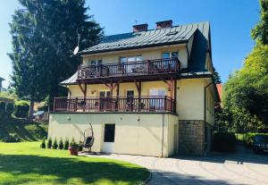 ein großes Haus mit Balkon darüber in der Unterkunft Willa Potok in Krynica-Zdrój