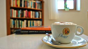 a cup of coffee on a table with a book at Proteas Hotel & Suites in Agios Prokopios