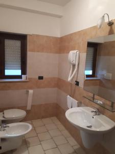 a bathroom with two sinks and a toilet at Lo Scoiattolo in Castellafiume