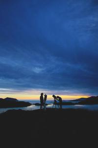 a group of people standing on a beach at sunset at The Old Cable Historic House & Seafood Restaurant in Waterville