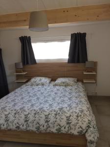 a bedroom with a large bed with a window at La grange in Machecoul