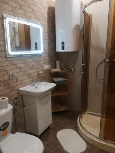 a bathroom with a toilet and a sink and a shower at Sweet-S in Boryspilʼ