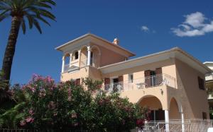 een gebouw met een palmboom ervoor bij Hotel et Appartements Reine D'Azur in Roquebrune-Cap-Martin