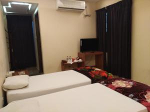 a hotel room with a toilet and a television at Bottomhill Palace Hotel in Sylhet
