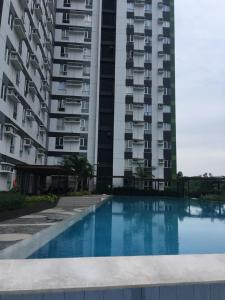 an apartment building with a swimming pool in front of it at Spacious 1 Bedroom Unit at Centrio Tower in Cagayan de Oro