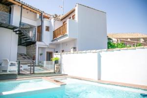 una piscina frente a una casa en Apartamentos Turísticos La Casa Vieja, en Sabiote