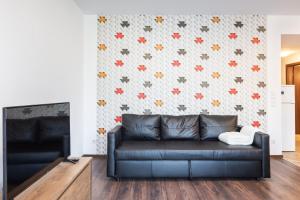Corvin Residence Apartments في بودابست: غرفة معيشة مع أريكة جلدية أمام الجدار