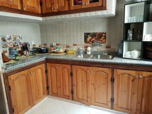 a kitchen with wooden cabinets and a sink at Maison Zaitouna in Marrakech +39 photos