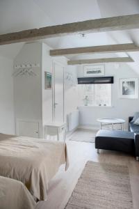 a white bedroom with a bed and a table at Mullbärsgårdens Bed and Breakfast in Visby