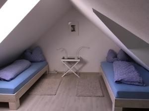 two beds in a attic room with a table at Storchenblick in Straupitz