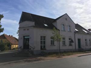 un edificio bianco con un tetto nero su una strada di Storchenblick a Straupitz