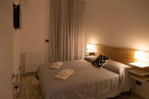 1 dormitorio con 1 cama con 2 toallas en UP&B Rooms Catania en Mascalucia