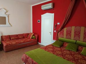 a red room with a couch and a bed at Alloggi Acquavita - checkin at "Alloggi SS Giovanni e Paolo" in Venice