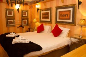 Un dormitorio con dos camas con almohadas rojas. en Copper Kettle B&B, en Killarney