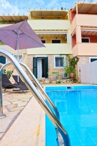 a swimming pool with a purple umbrella and a house at Agios Nikitas View in Agios Nikitas