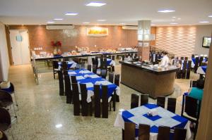 a restaurant with blue tables and chairs and a bar at Vitoria Palace Hotel in Mossoró
