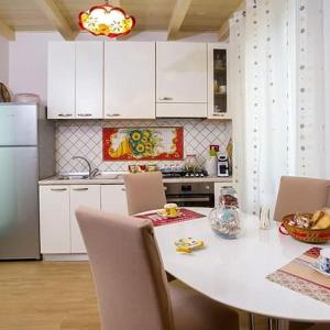 チェターラにあるStella Maris Houseのキッチン(白いテーブル、椅子、冷蔵庫付)