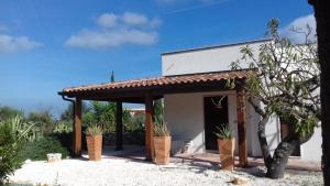 a building with a porch with potted plants in front of it at Masseria Due Torri in Monopoli