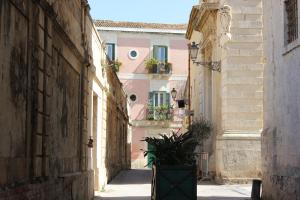 an alley with buildings and a potted plant at SIROIKIA luxury apartments in Siracusa