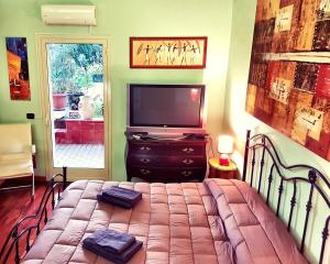 um quarto com uma cama com uma televisão e um televisionictericter em B&B Welcome em Pedara