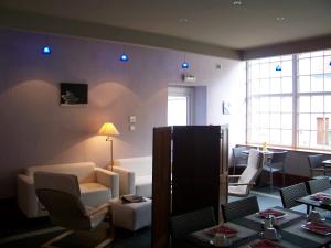 a living room with a couch and a table and chairs at Le Falken in Philippsbourg