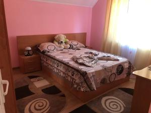 een kleine slaapkamer met een teddybeer op een bed bij Steluța in Călimăneşti