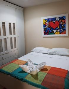 a bed with a white flower on a colorful blanket at Pousada Terra Garrida in Maceió
