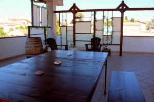 - une table en bois dans une chambre avec des chaises et des fenêtres dans l'établissement Villa Viola, à Agnone Bagni