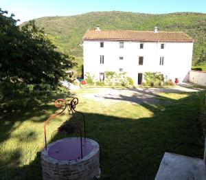 un edificio y una estatua delante de un patio en Chambre d'hôte Le Clos d'Audio à Riols, en Riols