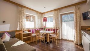 un soggiorno con tavolo, sedie e divano di Schöne Aussicht Apartments a Tux