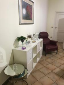 ボローニャにあるOlly Apartmentsの白いキャビネット、椅子、テーブルが備わる客室です。