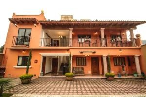 ein großes orangefarbenes Haus mit einer Terrasse und einem Balkon in der Unterkunft Posada Hacienda Real in Tepoztlán