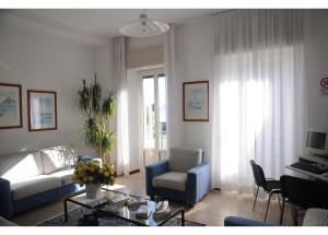uma sala de estar com um sofá e uma cadeira em Hotel Italie et Suisse em Stresa