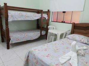 a bedroom with two bunk beds and a doll laying on the bed at Pousada Pesque Park in Boracéia