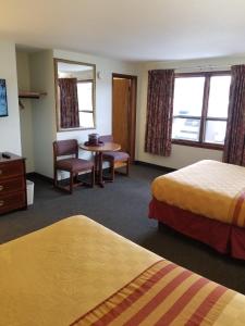 ein Hotelzimmer mit 2 Betten, einem Tisch und Stühlen in der Unterkunft Budget Inn And Suites Eagan in Eagan