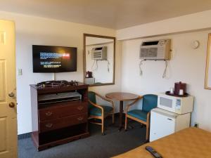 Zimmer mit einem Schreibtisch, einem Tisch und Stühlen in der Unterkunft Budget Inn And Suites Eagan in Eagan