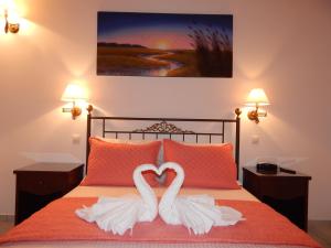 Dos cisnes forman un corazón en una cama en Tinos Suites & Apartments, en Agios Ioannis