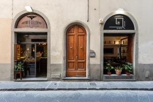 a building with two arched windows and a wooden door at Lovewknds - Topfloor with Duomo View in Florence