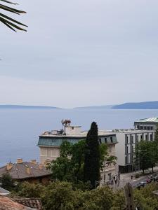 a view of a building with the ocean in the background at Sunny apartment 150 m from the sea in Opatija