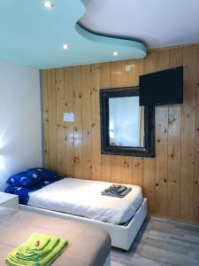 1 Schlafzimmer mit 2 Betten und einem Spiegel in der Unterkunft Central Greenlife in Tarvis