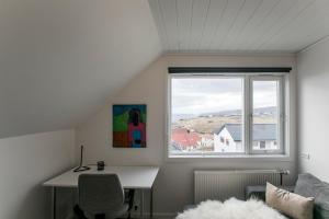 a white room with a desk and a window at FaroeGuide in Tórshavn