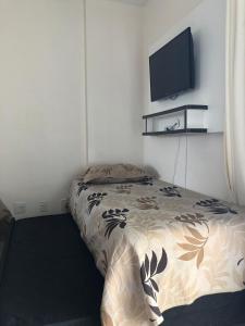 Schlafzimmer mit einem Bett und einem Flachbild-TV in der Unterkunft Flat em Caldas Novas in Caldas Novas