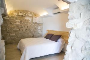 Un dormitorio con una cama frente a un muro de piedra. en Apartamentos Turísticos La Casa Vieja, en Sabiote 37 fotos más