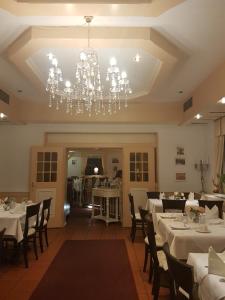 a dining room with white tables and a chandelier at Hotel Restaurant Knechtstedener Hof in Dormagen +15 photos