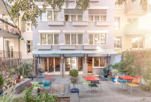 un patio extérieur avec des tables et des chaises en face d'un bâtiment dans l'établissement Hotel Birsighof Basel City Center, à Bâle